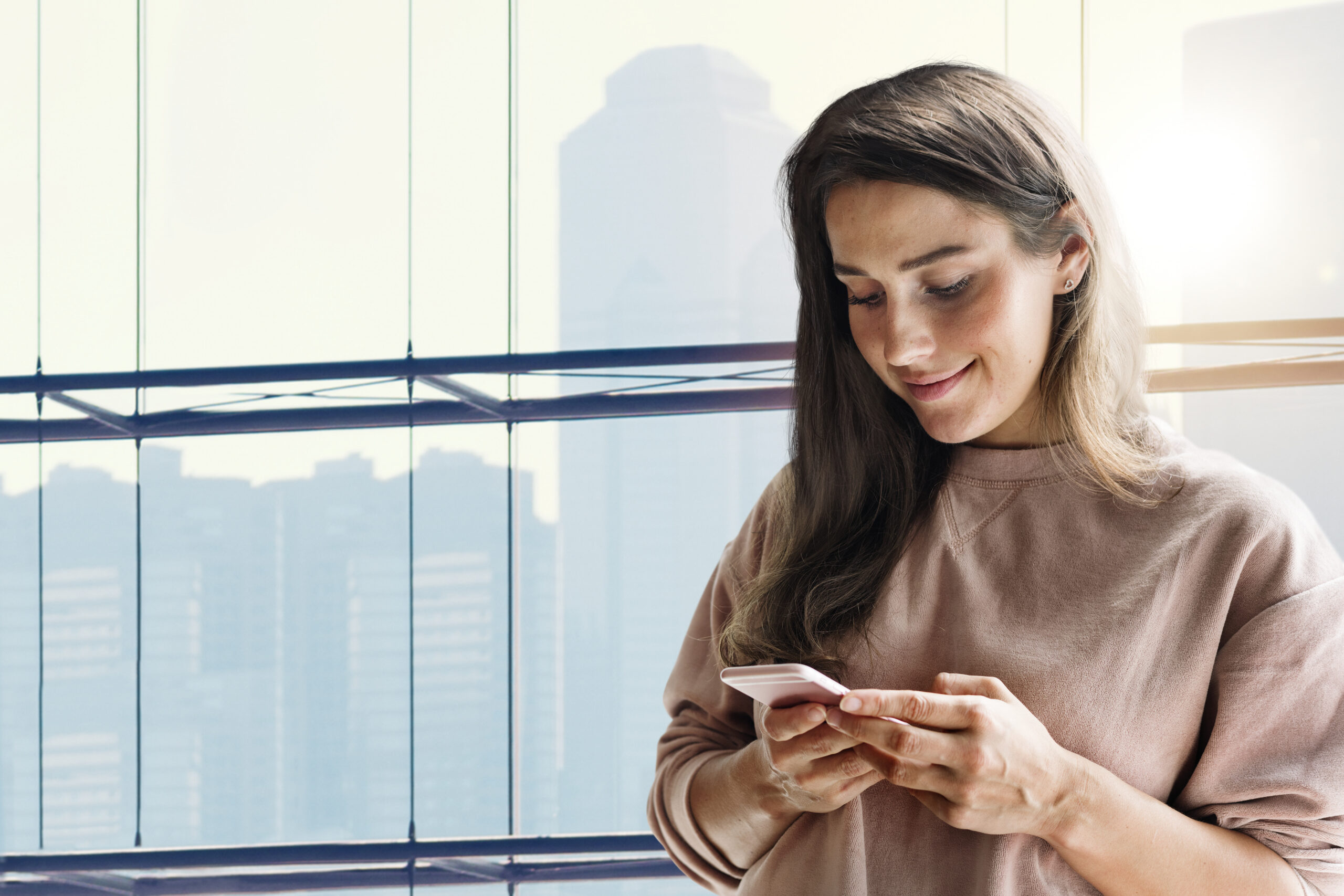 Woman holding smartphone background in the new normal with city view remixed media